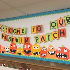 a welcome to our pumpkin patch banner hanging from a bulletin board with cutouts on it