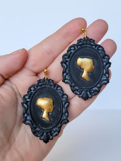 This set is Victorian-inspired and a statement piece! 🖤 The silhouette detail in the center has been hand-painted gold. Because of their polymer clay construction, these earrings are lightweight and comfortable to wear.  The hardware is a gold color and hypoallergenic. Each pair of earrings comes with gold earring backs and clear, silicone backs.  CARE: Wipe gently with a soft, damp cloth. Victorian Cameo, Gold Earring, Earring Backs, Polymer Clay Earrings, Clay Earrings, Jewelry Earrings Dangle, Gold Earrings, Gold Color, Etsy Earrings