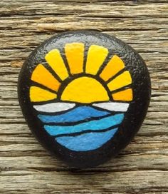 a painted rock sitting on top of a wooden table