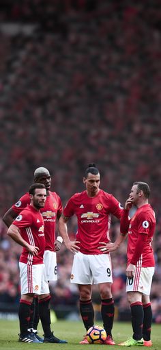 three soccer players are standing on the field