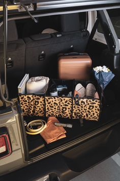 the trunk of a car with luggage and other items in it