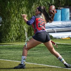 a woman catching a football on top of a field