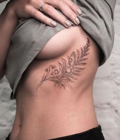 a woman's stomach with a flower tattoo on it