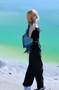 a woman with blonde hair walking on the beach