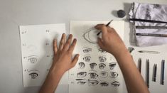 someone is doing something on paper with their hands and eyes drawn in front of them