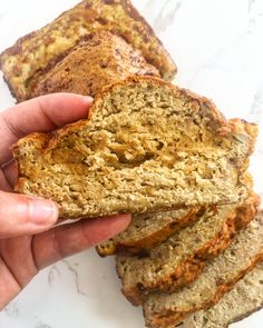 a person holding a loaf of banana bread in their left hand and the other half sliced