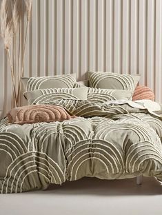 the comforter is made up and has an art deco pattern on it, along with two pillows