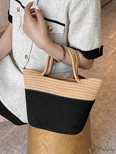 a woman is holding a straw bag in her hand