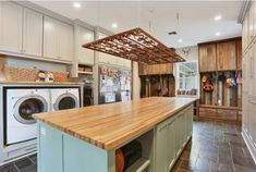 a kitchen with an island, washer and dryer in the middle of it