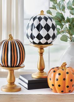 three decorative pumpkins sitting on top of a table