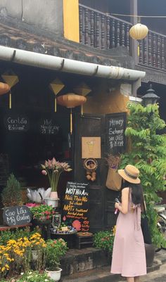 a woman standing in front of a flower shop