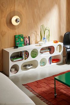 a living room filled with furniture next to a wooden wall