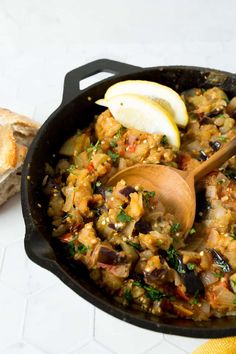 a skillet filled with food and a wooden spoon