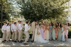 a group of people standing next to each other in front of a tree and building