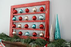 a red wooden shelf with christmas ornaments hanging from it