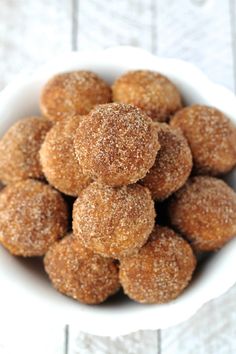 a white bowl filled with sugar covered donuts