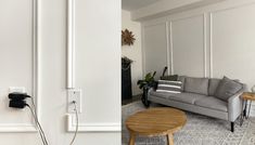 a living room filled with furniture and a wall mounted phone plugged into the wall