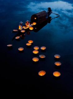 lanterns floating in the water with people on them