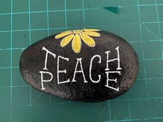 a rock with the words teach painted on it