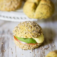 a bagel sandwich sitting on top of a white plate next to other bagels