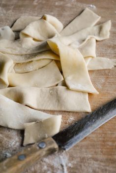 some uncooked ravioli on a cutting board with a knife