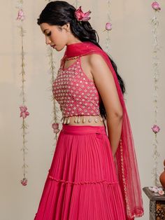 A three-piece fuchsia pink mirror lehenga set from the Redpine Designs collection. This pretty fuchsia pink mirror crop top blouse is paired with a pleated pink lehenga. The fuchsia pink color with mirror, poth, cutdana, shell, kasab work enhances the graceful georgette lehenga set. The fuchsia pink lehenga has beautiful pleats, layers, and frills with flare style. The fuchsia pink blouse features shell tassels, heavy mirror embroidery and a scoop neckline. The outfit is completed with a pink ne Off Shoulder Lehenga, Mirror Lehenga, Shell Tassels, Royal Blue Lehenga, Model Blouse, Raw Silk Lehenga, Georgette Lehenga, Yellow Lehenga, Mirror Embroidery