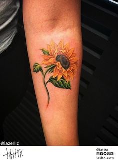 a woman's arm with a sunflower tattoo on it