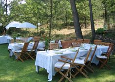 an outdoor dining area with tables, chairs and umbrellas set up for a meal