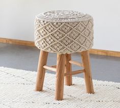 a wooden stool sitting on top of a white rug