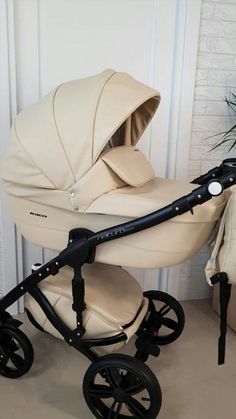 a baby stroller is sitting on the floor next to a potted plant