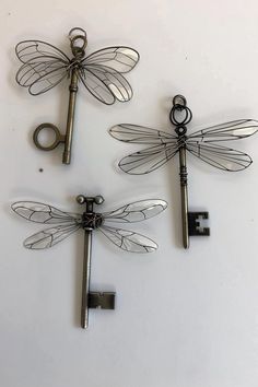 three dragonflys are sitting next to each other on a white surface with keys