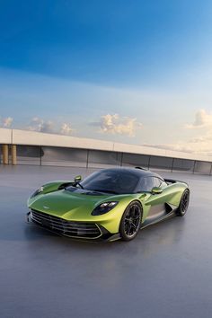 a green sports car parked on top of a parking lot