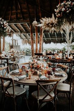 a table set up for an event with floral centerpieces and place settings on it