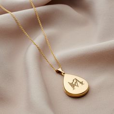 Our beautiful 18ct Yellow Gold Plated Floral Engraved Initial Droplet Locket Necklace is the perfect way to keep your memories close.  Each droplet locket is made from 18ct yellow gold plated Sterling Silver and suspended from a 18" sterling silver chain. Personalise it with the engraved intricate initial design of your choice. 18ct Gold plated Sterling silver. We make our jewellery using the finest quality 925 Sterling Silver. Most of our Silver Jewellery can also be plated with a thick layer ( Luxury Engraved Custom Necklace For Wedding, Teardrop Engraved Necklace For Weddings, Etched Yellow Gold Keepsake Jewelry, Custom Engraved Yellow Gold Necklace For Wedding, Elegant Etched Necklaces For Memorial, Etched Yellow Gold Necklace For Wedding, Yellow Gold Etched Necklace For Wedding, Gold Teardrop Keepsake Jewelry, Teardrop Engraved Necklace For Anniversary