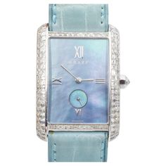 Graff Mother of Pearl and diamond wristwatch. The watch features rectangular Mother of pearl dial, case accented with round and square shaped diamonds, equipped with blue leather strap. Automatic movement. Crafted in platinum and 18k white gold. There is 120 of square cut diamonds and one round brilliant cut diamond, with total carat weight of approximately 4.00ct, color G-H, clarity VS. Signed: Graff London. Numbered: 0043. Marked: PT950, Platinum, G XXXII (case), 750 (clasp) and Swiss Marks. C Timeless Blue Rectangular Watch, Blue Rectangular Timeless Watch, Elegant Blue Rectangular Watch, Blue Diamond Watch With Diamond Hour Markers For Anniversary, Blue Diamond Luxury Watch For Formal Occasions, Blue Diamond Watch For Anniversary, Luxury Blue Diamond Watch For Formal Occasions, Blue Luxury Diamond Watch For Formal Occasions, Elegant Blue Diamond Watch