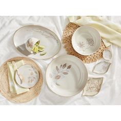 the table is set with plates and napkins on it, along with a straw hat