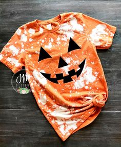 an orange shirt with white sprinkles on it and a jack - o'- lantern face