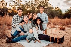 a family sitting on a blanket in the middle of a field