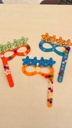 three different colored paper scissors on a table with the words 2012 spelled out in them