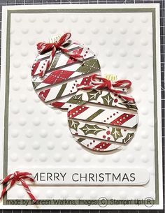 a merry christmas card with two ornaments on the front and bottom, tied in red ribbon