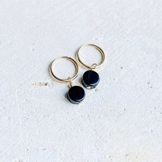 Dainty 14k Gold Filled Endless hoop earrings with Black Onyx coin charm Size - 14mm hoops with a 6-7 mm Black Onyx charm - B L A C K   O N Y X -  Helps with : Grounding, Protection, willpower, focus, and strength - C H A K R A - Root - GOLD FILLED -    Gold-filled jewelry is composed of a solid layer of gold mechanically bonded to a base of either sterling silver or some base metal. Gold Filled is much more affordable than solid gold, but with the same beautiful color and shine. It is more durable than plated metals because the gold content is significantly thicker. - CARE & CLEANING -  Here are some tips to keep your jewelry in great shape for many years: > Jewelry should be put on after products like lotion, perfume, and hairspray  > Do not wear jewelry to swim or shower > To clean, wash Gold Onyx Dangle Earrings, Black Onyx Hoop Earrings, Black Onyx Oval Earrings, Onyx Drop Earrings With Black Enamel, Black Enamel Onyx Drop Earrings, Biwa Pearls, Black Onyx Earrings, K R, Onyx Earrings