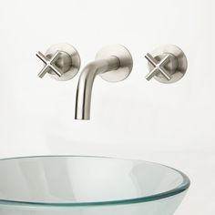 a glass bowl sink with two faucets on the side and an advertisement for signature hardware