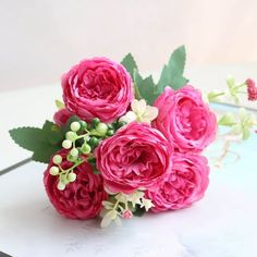 a bouquet of pink flowers sitting on top of a table