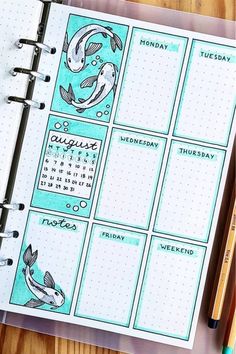 a planner with fish on it and pencils next to it