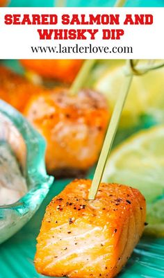 grilled salmon and whiskey dip on a green plate with lemon wedges in the background