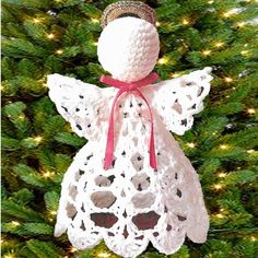 a crocheted angel ornament hanging from a christmas tree