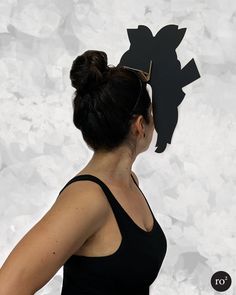 a woman wearing a black top with a paper cut out of it's head