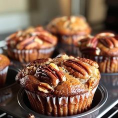 several muffins with pecans and nuts in them sitting on a cooling rack