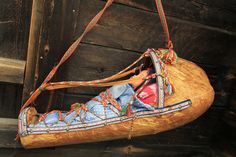 a wooden shoe hanging from the side of a building with a cloth bag on it