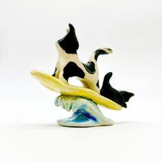 three black and white ceramic figurines on top of each other in the shape of bananas